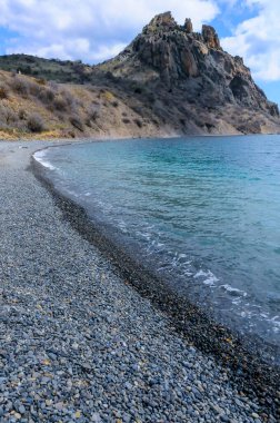 Kara-Dag, ulusal parktaki Karadeniz kıyısındaki volkanik kayalar, kumsaldaki yuvarlak çakıl taşları, Kırım