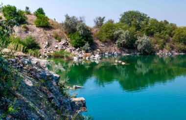 Sel basmış granit ocağının turkuaz berrak suyla manzarası, Ukrayna
