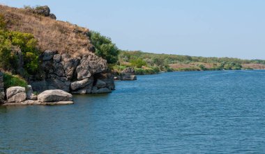 Granit bankaların arasında yavaşça akan bir nehrin yatağı Ukrayna 'nın pitoresk bitki örtüsüyle kaplıdır.