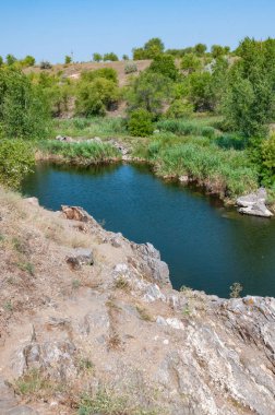 Granit kayaların arasındaki düz bir nehrin sakin durgun suları, Ukrayna