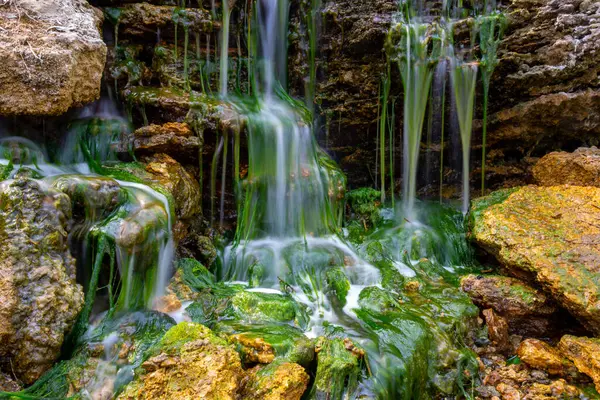小瀑布落在布满淡水绿藻的石头上 — 图库照片