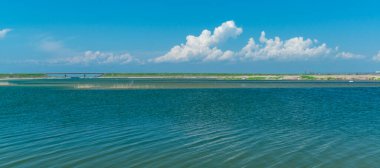 Mavi gökyüzüne karşı beyaz kabarık bulutlar, önplanda göl, Ukrayna