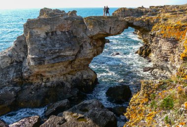 BULGARIA, TYULENOVO - 26 AĞUSTOS 2014: Bulgaristan 'ın Tyulenovo kasabası yakınlarındaki dik bir kıyıda bir kayanın ortasında duran insanlar