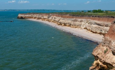 Ukrayna 'nın Berezan adasında yaban bozkır bitkileriyle kaplı dik kayalık ve kabuklu kaya kıyıları.