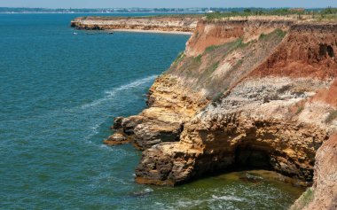 Ukrayna 'nın Berezan adasında yaban bozkır bitkileriyle kaplı dik kayalık ve kabuklu kaya kıyıları.