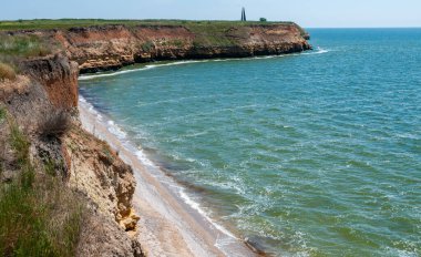 Ukrayna 'nın Berezan adasında yaban bozkır bitkileriyle kaplı dik kayalık ve kabuklu kaya kıyıları.