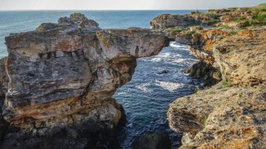 Bulgaristan 'ın güneyindeki Tyulenovo kasabası yakınlarındaki kaya parçalarından oluşan kıyı kayalarındaki büyük kemer.