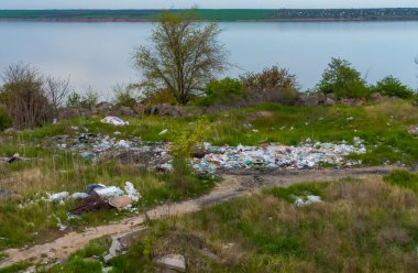 ODESSA bölgesi, UKRAINE - 30 Nisan 2017: Baraj gölünün kıyısında plastik çöp yığınları. Doğanın ekolojisi, düzensiz çöplük