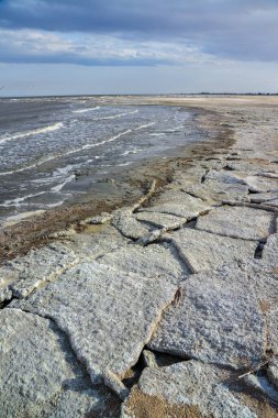 Yüksek çözünürlüklü bir gölün kıyısı tuzlu sodyum klorür ile kaplıdır. Kaliforniya çölü.