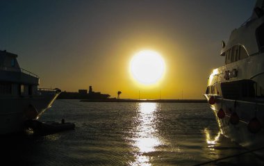 EGYPT, MARSA ALAM - 20 Nisan 2010: Kızıl Deniz, körfezin kenarından Hurghada, Mısır 'da teknelerle birlikte gün doğumu