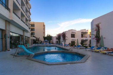 HURGHADA, EGYPT - 10 Kasım 2004: Bir işçi Hurghada, Mısır 'da bir otel avlusunda yüzme havuzu temizliyor