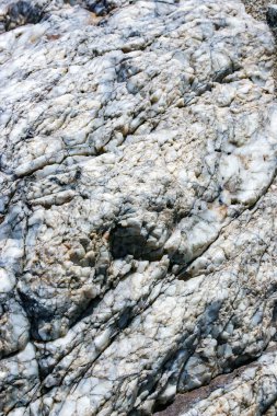 Arizona çölündeki Ölüm Vadisi 'ndeki dağlarda renkli kayalar arasında beyaz bir kuvars tabakası.