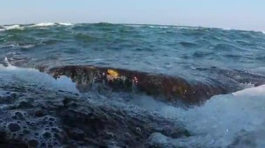 Karadeniz 'de fırtına, köpüklü dalgalar kıyıya yakın kıyı kayalarını istila ediyor ve kamera Odessa' yı istila ediyor.