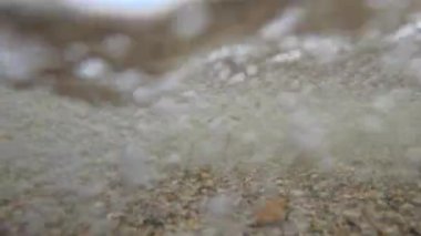 Kumlu bir sahil, kum ve çakıl taşlarının hidrodinamiği Karadeniz sahilindeki dalgalarda hareket ediyor, Odessa