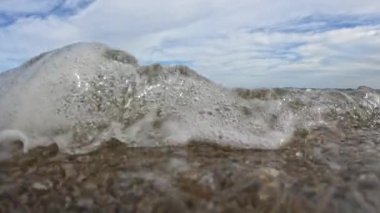 Kumlu bir sahil, kum ve çakıl taşlarının hidrodinamiği Karadeniz sahilindeki dalgalarda hareket ediyor, Odessa