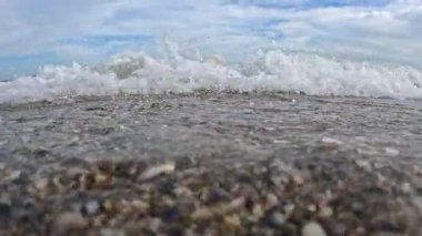 Kumlu bir sahil, kum ve çakıl taşlarının hidrodinamiği Karadeniz sahilindeki dalgalarda hareket ediyor, Odessa