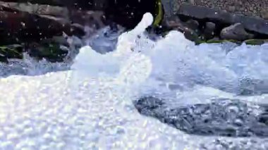 Kaynak suyu paslı bir borudan Karadeniz 'e akar. Su damlaları ve kabarcıkları kameraya çarpar. Yavaş çekim videosu.