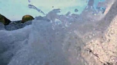 Su köpürüyor ve eski bir borudan Karadeniz 'e akıyor, köpüklü su damlaları yeşil yosunlarla kaplı taşları yıkıyor, yavaş çekim videoları var..