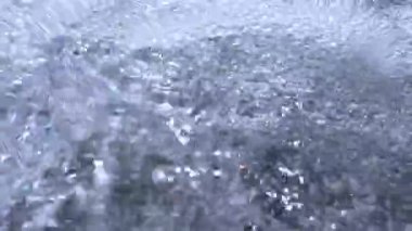 Hızlı akan saf kaynak suyu, hava kabarcıklarında parlayan ışık.