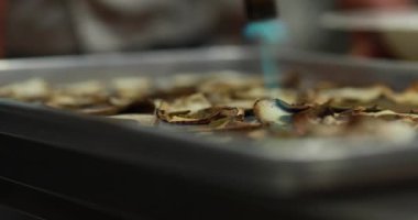 Mutfağın yemek ve mantarları yaktığı profesyonel bir mutfak. Şef tabağı şişirir..