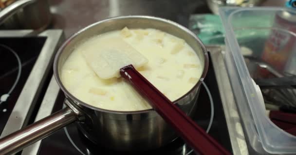 白いソースをかけた鍋 レストランでプロのキッチンで料理を作る — ストック動画