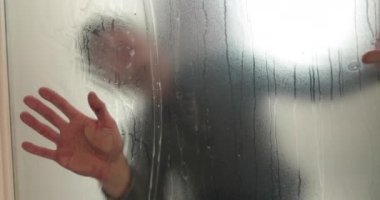 Adamın biri cam kapıyı opak yapmak için klinikteki cam kapıya buzlu bir kaplama serpiştiriyor. Cama mat kaplama uyguluyorum..