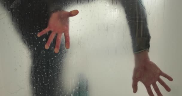 ある男は ガラスのドアを不透明にするために クリニックのガラスドアに凍ったコーティングを貼ります ガラスにマットコーティングを施す — ストック動画