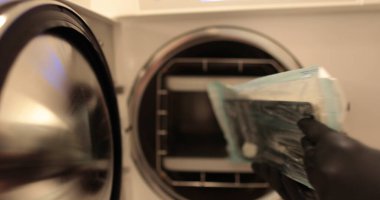 Otoklavda diş aletlerinin dezenfekte edilmesi. Tıbbi araçları dezenfekte etmek için otomatik klavye kullanma süreci.