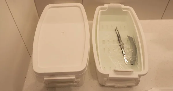 看護師は 殺菌と消毒のための箱に医療機器を入れる ロイヤリティフリーのストック写真