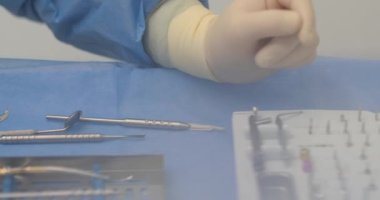 Çalışan bir aletle doktorun elleri. Diş tedavisine hazırlık ve işlem. Modern bir dişçinin muayenehanesinde diş aleti. 4K 'da yakın plan, UHD