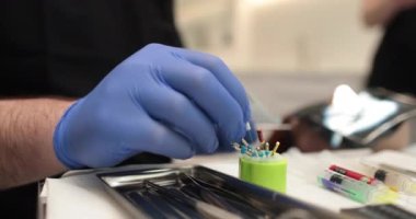 Bir hemşirenin dişçide bir doktor tarafından kullanılmak üzere hazırladığı protestan iğneleri..