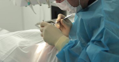 Diş tedavisi, yakın plan. Bir dişçi bir diş prosedürü uygular. Dişçinin elleri iş başında. Diş hekiminde tedavi sürecinde ağız boşluğu.