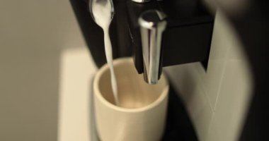 Kahve yapma süreci. Beyaz bardakta kahve yapan bir kahve makinesinin yakın çekimi. Kahve akışını profesyonel bir makineden bir fincana dolduruyorum..
