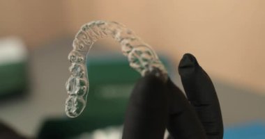 Doktorun ellerinde dizilim aletleri, lastik eldivenler diş düzeltme için modern aletler tutuyor..
