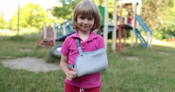 包帯に包まれた腕を持った小さなハンサムな少年 遊び場で負傷した子供 — ストック動画