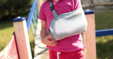 Bandajlı bir elin yakın çekimi. Açık bir alanda kolunda bandaj olan bir çocuk. Sınırlı insan hareketi. Çocuk yaraları.