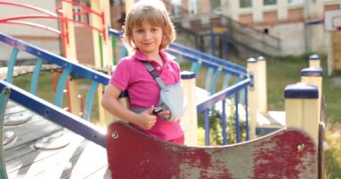 Bandajlı kolu kırık yakışıklı bir çocuk. Çocuk yaraları, kırık kol, bandajlı kol..