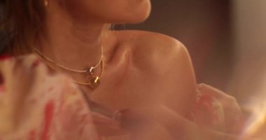 Gece elbisesi giymiş bir kadın aynanın önünde makyajını düzeltir. Karanlık bir odada aynanın önünde güzel bir kız. Video yansıtma.