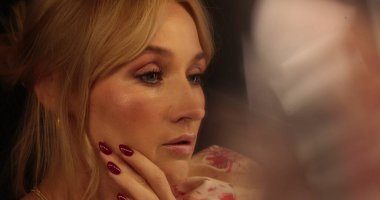 Güzel bir sarışının portresi aynanın önünde duruyor, kıyafetlerine bakıyor ve makyajını yapıyor. Aynanın önünde bir kadının yüzünü yakından çek..