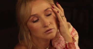 Güzel bir sarışının portresi aynanın önünde duruyor, kıyafetlerine bakıyor ve makyajını yapıyor. Aynanın önünde bir kadının yüzünü yakından çek..