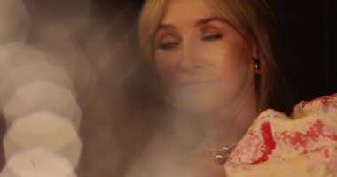 Güzel bir sarışının portresi aynanın önünde duruyor, kıyafetlerine bakıyor ve makyajını yapıyor. Aynanın önünde bir kadının yüzünü yakından çek..