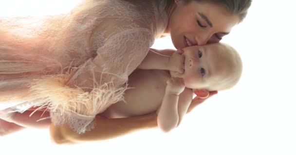 一个漂亮的母亲抱着一个赤身裸体的小孩的垂直镜头 一位有着漂亮发型和妆容的年轻母亲抱着一个婴儿 靠近点 慢动作 — 图库视频影像
