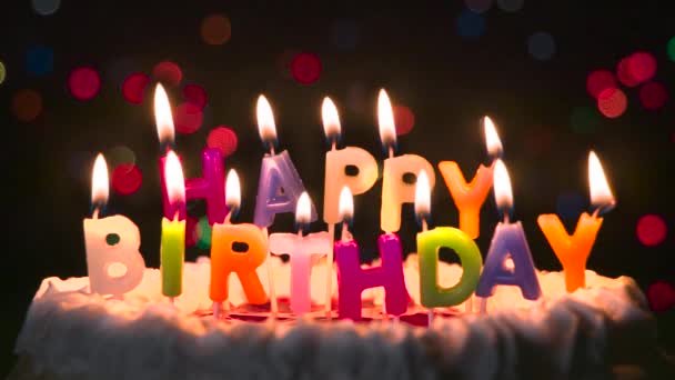 生日时和蜡烛一起做蛋糕 用蜡烛做的蛋糕 上面刻着 生日快乐 在背景中 闪烁和移动的灯光在黑暗中摇曳 — 图库视频影像