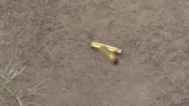 坠落的热弹壳 黄铜弹壳从自动武器掉到地上 — 图库视频影像