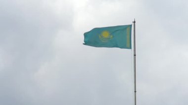 Bulutlu Gökyüzünde Kazakistan Bayrağı. Kazakistan Cumhuriyeti Ulusal Bayrağı bulutlu gökyüzünde dalgalanıyor. Yavaş Hareket