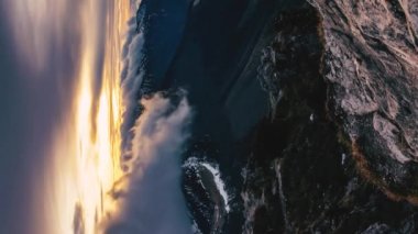 Vertical video of Golden Sunset with fast clouds sky motion over alps mountains ridge Time lapse. Travel tourism adventure, Panorama Background Ideal for social media stories 