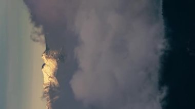 Vertical video of Winter mountains hidden in fast clouds motion at cold sunrise in frozen nature Time lapse. Outdoor adventure Background video Ideal for social media stories