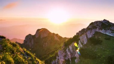 Time lapse video of Sunset in rocky alps mountains peak with fast clouds motion in colorful sky in summer evening nature. Timelapse, Zoom in, 4K. 