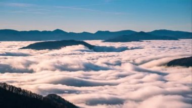 Foggy clouds flows like a river in misty mountains nature in sunny spring morning Time lapse 4K Tilt down 