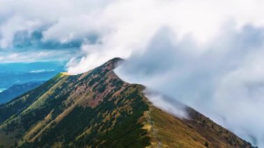 Misty mountains nature hidden in low clouds motion fast in moody dramatic day in spring season. Time lapse Background Zoom out 